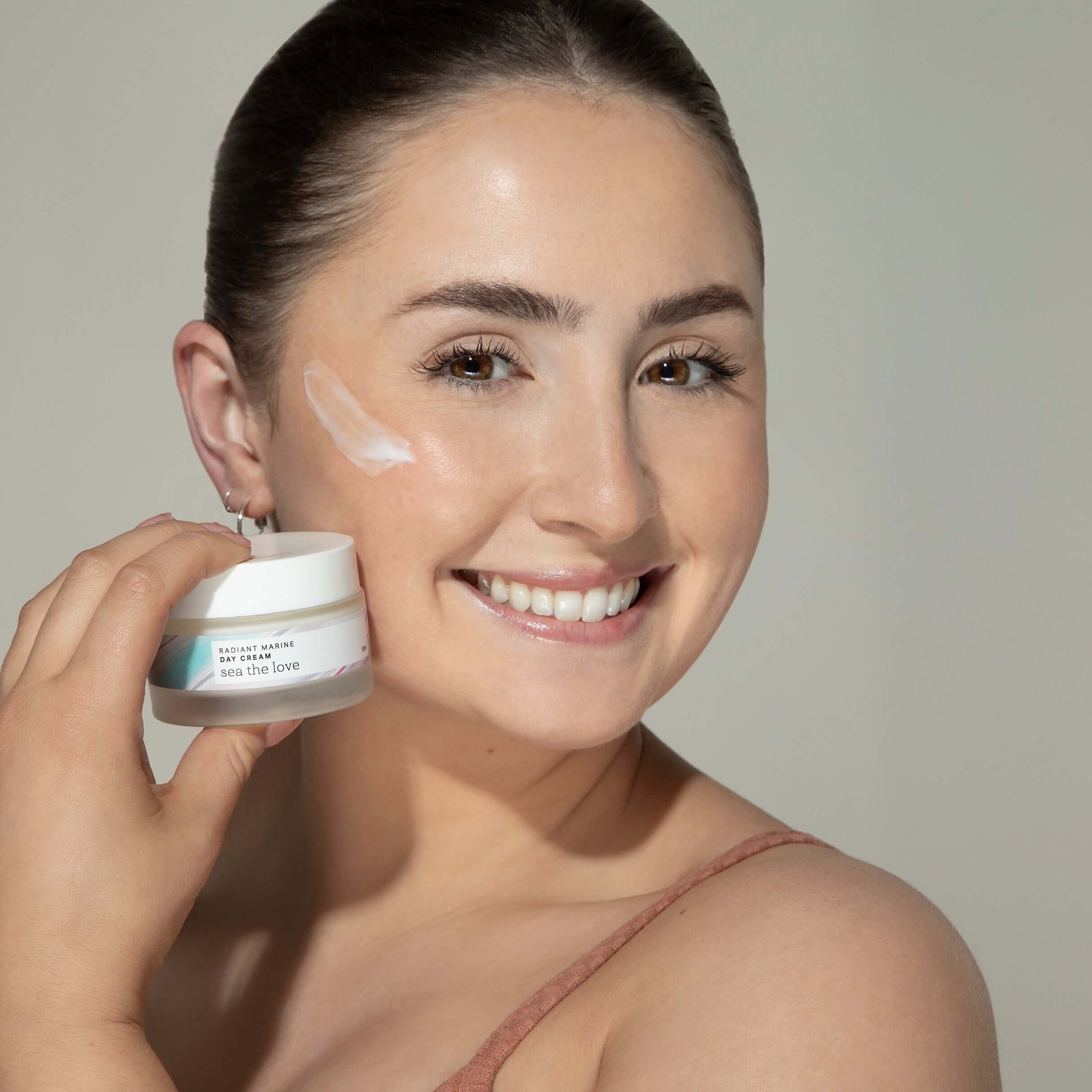Woman applying Radiant Marine Day Cream with marine magnesium, sea fennel, and hyaluronic acid