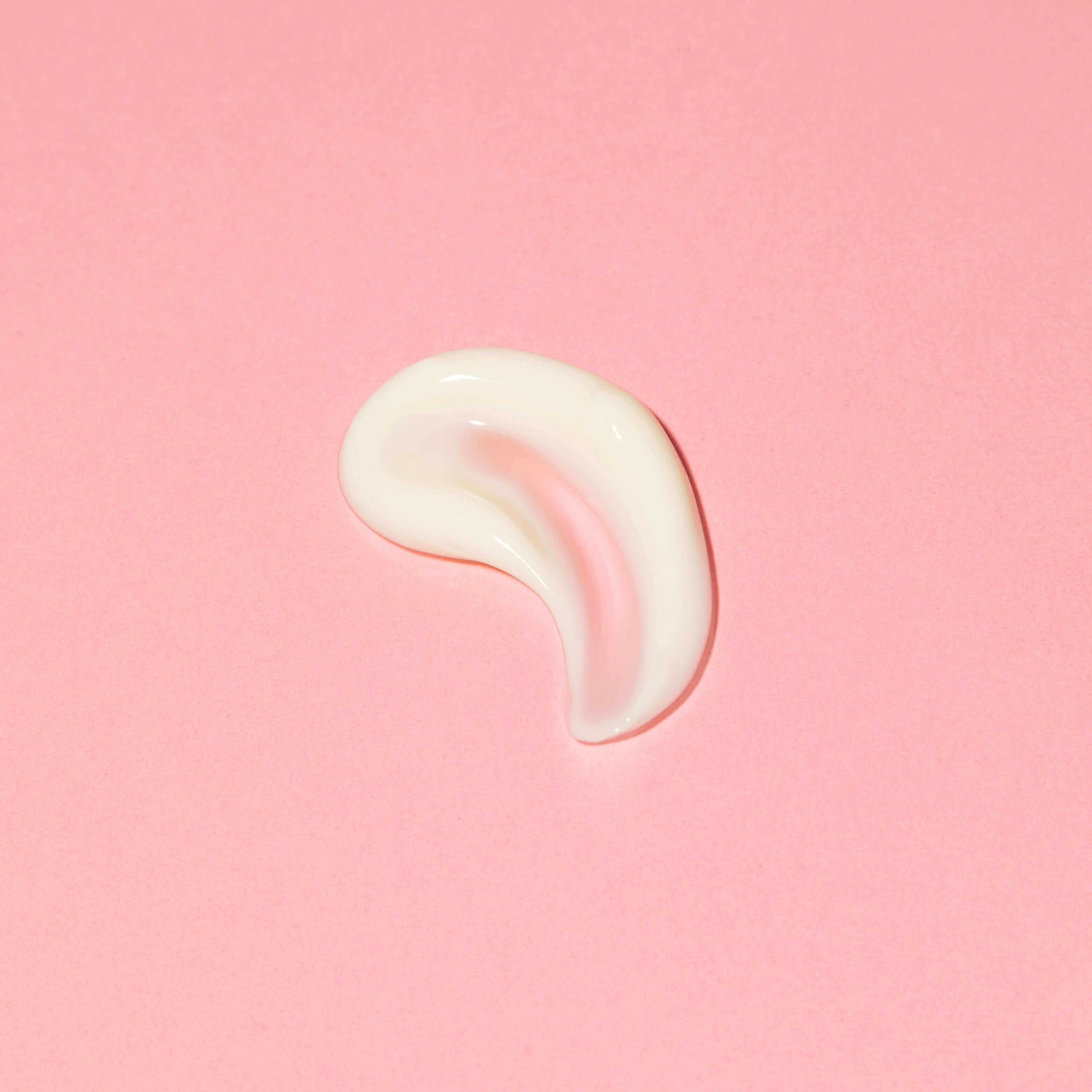 Swatch of Sleepy Beach Night Cream on a pink background showcasing its smooth, creamy texture.