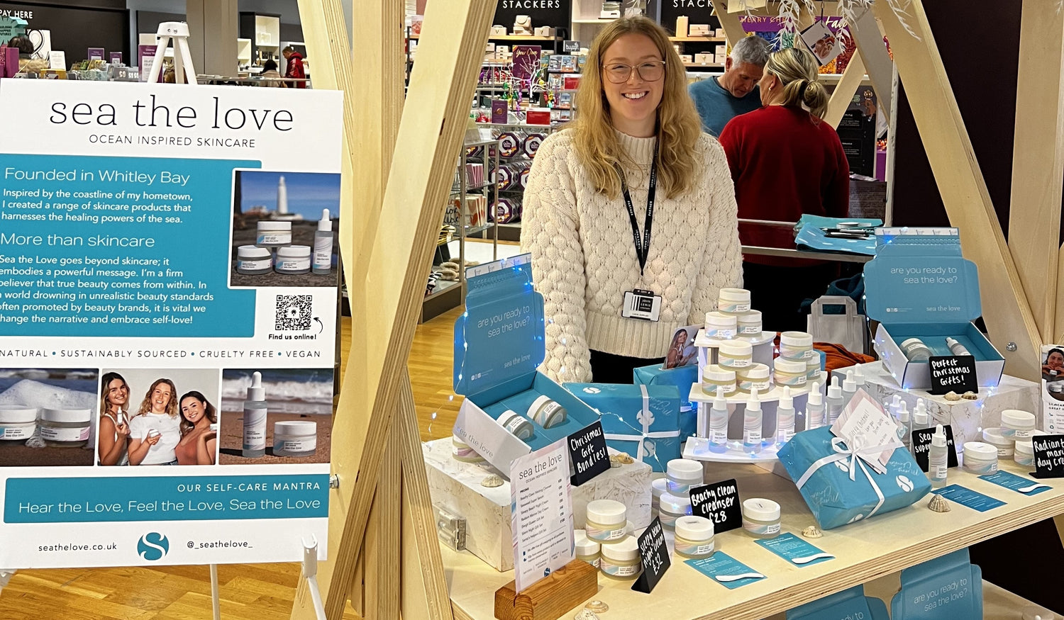 annabelle stood behind her stall in John Lewis, with products laid out in front of her