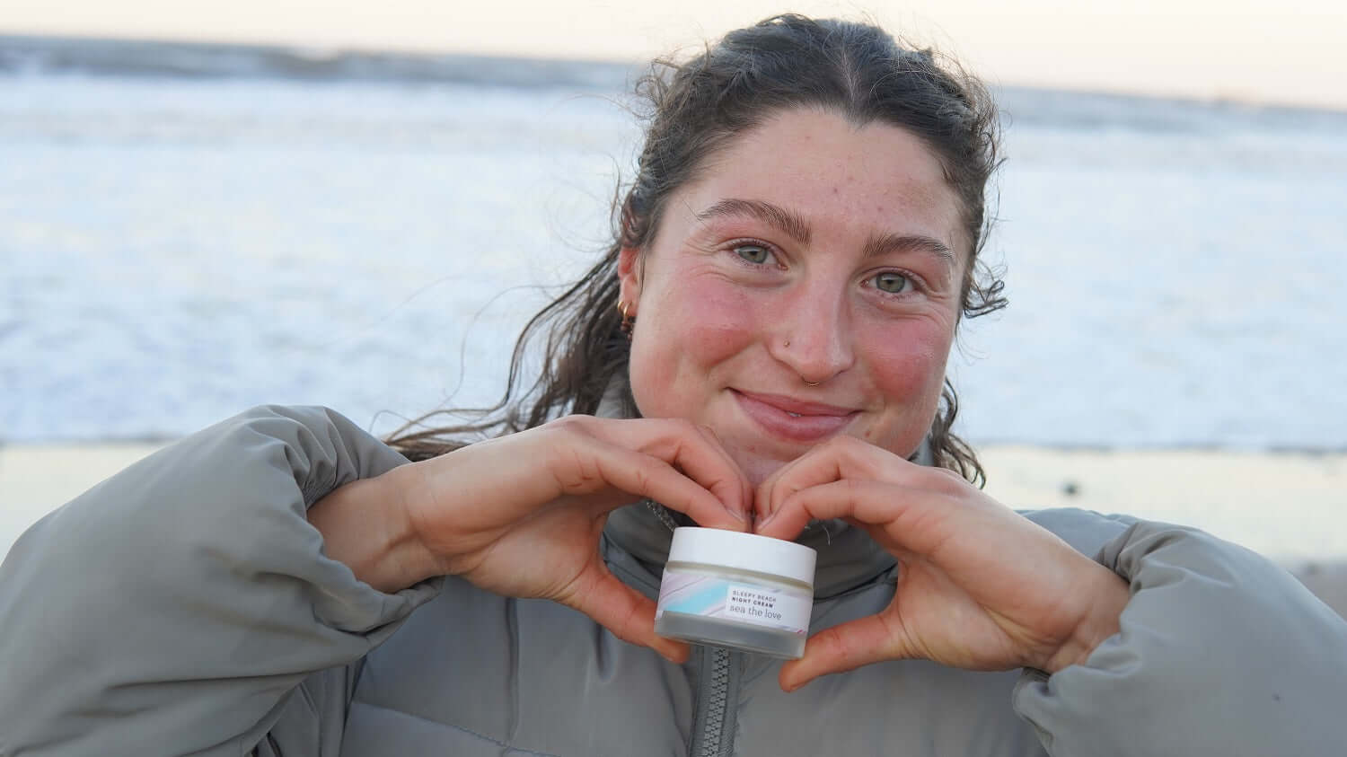 girl at the beach holding a moisturiser