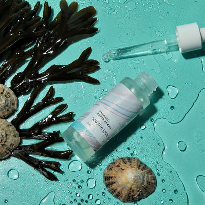 Seaweed Super Serum infused with sea minerals and hyaluronic acid for hydrating and firming skin, placed on a blue background with seaweed and seashells.