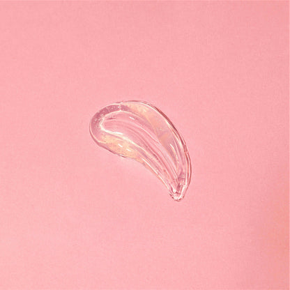 Swatch of Beachy Clean Melting Cleanser on a pink background showcasing its smooth, gel consistency. 